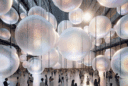 Futuristic atrium art installation with glowing translucent spheres, refracting light and creating an immersive multisensory atmosphere.