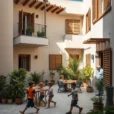 Editorial photograph of a contemporary social housing courtyard in the Balearic Islands, with pale mineral walls.