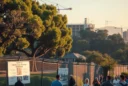 Editorial photograph of a West Coast urban edge at late afternoon: a dense apartment construction site.