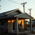 Editorial photograph of a modest contemporary home during a summer blackout, its deep overhangs and exterior.