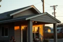 Editorial photograph of a modest contemporary home during a summer blackout, its deep overhangs and exterior.