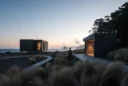 Editorial photograph of a contemporary monolithic beach house in a cleared coastal landscape near Victoria’s Otway.