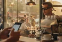 Editorial photograph inside a busy street-corner café at late afternoon: a customer wearing black Ray-Ban Meta.