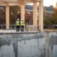 Editorial photograph of a university construction site in Amherst, Massachusetts, where a new mass-timber frame rises.
