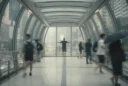 Editorial photograph inside an enclosed pedestrian footbridge in Hong Kong’s Central district on a humid summer.