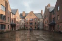 Editorial photograph of a contemporary brick boarding courtyard in Winchester, Hampshire, framed by gabled residential buildings.