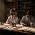 Editorial photograph of a staged research session in a Florence perfumery archive, connecting historic apothecary culture.