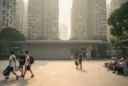 Editorial photograph of a neighborhood civic forecourt in Shenzhen’s Nanshan district, dense residential towers rising behind.