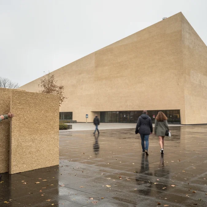 Editorial photograph of a contemporary wedge-shaped cultural building in Eindhoven, its hempcrete envelope finished with earthy.