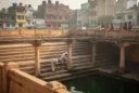 Editorial photograph of a historic sandstone stepwell in Rajasthan, India, viewed diagonally from an upper landing.