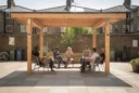 Editorial photograph of a modest timber shade structure in a community courtyard in Camden, north London.