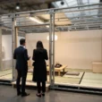 Editorial photograph interpreting the collectible-architecture debate at Design Miami.Paris: a modest demountable house displayed inside.