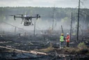 Editorial photograph of drone-assisted reseeding in a wildfire-damaged boreal landscape in northern Quebec, Canada. An unbranded.