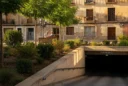 Editorial photograph in Zaragoza’s historic center, a planted public square beside an underground parking entrance, framed.