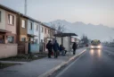 Editorial photograph on Santiago de Chile’s metropolitan edge at early morning, showing low-rise subsidised housing beside.